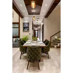 This dining space combines modern and classic elements. We used plush, tufted green velvet chairs for comfort and style, set against a clean marble floor and a wooden-beamed ceiling.