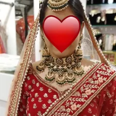 A client trying on a heavy green meenakari and Kundan bridal set in my store. I always help my clients find the perfect match for their big day.