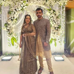 Here is a perfect example of a coordinated reception look. The groom's Indo-Western jacket has embroidery that subtly matches the bride's heavily embellished brown lehenga.