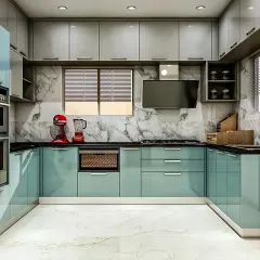 A U-shaped modular kitchen in a striking combination of pastel blue and grey. The design includes a dedicated space for appliances and a marble-patterned backsplash for a touch of luxury.