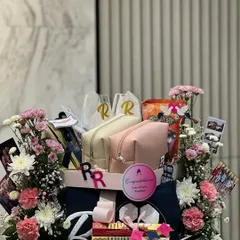 This wedding hamper tells the story of a football fanatic and an animal lover. I used custom embroidery on towels and pouches, along with personalized wine glasses and polaroids, to create a gift that is truly theirs.