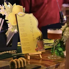 A custom-designed 'Baby Booze Bar' menu for a citrus-themed shower, featuring creatively named mocktails. This is a fun way to carry the theme through to the food and beverage service.
