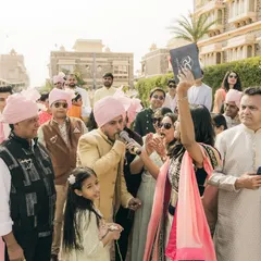 In the heart of the baraat, interacting with the groom and his family. It's all about creating a personal connection and making sure the groom feels like a king.