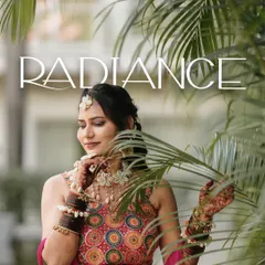 A radiant portrait of the bride-to-be during her Haldi ceremony, framed by palm leaves.