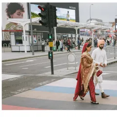 A newly married Shaan and Shubham cross a street in London, their traditional attire a striking contrast to the urban landscape. This is the kind of unique, adventurous storytelling we love.