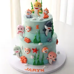 A fun and colorful Baby Shark theme cake for baby Jaryn’s 1st birthday. This two-tiered cake is covered in my signature colored ganache and features the whole shark family, all handmade from fondant.