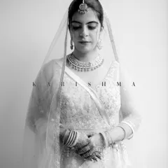 A serene and elegant black and white bridal portrait. Karishma's calm demeanor and the delicate details of her lehenga are beautifully rendered in this timeless shot.