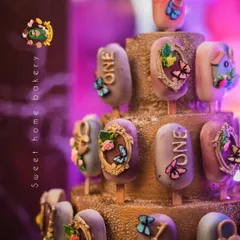 A closer look at the detailed work on my enchanted forest cakesicles. Some are decorated with ornate frames and butterflies, while others are marked with the number 'one' for the special birthday celebration.