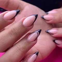 A dramatic and edgy take on the French manicure. This look features a sharp, pointed black tip on a natural base for a high-contrast, minimalist statement.