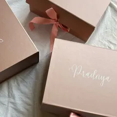 The beauty is in the details. These elegant rose gold boxes are personalized with each bridesmaid's name in a beautiful script, creating a sophisticated and personal first impression before they even see the gifts inside.