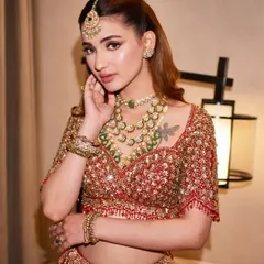 This shot highlights the beautiful contrast of green jewelry against the rich red lehenga, a classic combination that always feels fresh and sophisticated.