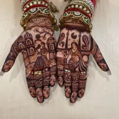 A classic Karwa Chauth design that tells a story across both hands. One hand shows a woman looking at the moon through a sieve, and the other features her partner, set against a backdrop of traditional architecture.