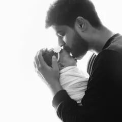The quiet, tender moments are often the most powerful. A father's gentle kiss on his newborn's head speaks volumes, capturing a bond that is deep, protective, and full of love from the very first day.
