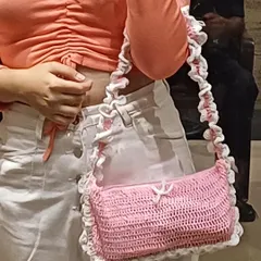 Close-up of the pink ruffle bag, showing the texture of the crochet and the frilly strap. Every single one is handmade by me.