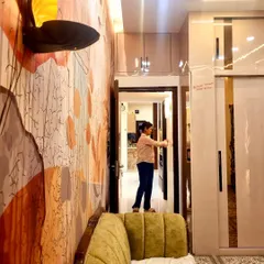 This shot highlights the custom wallpaper and unique wall lamp that add a personal and artistic touch to this beautifully designed closet room.