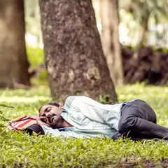 A moment of peace in the middle of a busy city. I saw this man taking a nap in Cubbon Park, completely at ease in nature. It's a simple, candid shot that finds stillness in an urban environment.