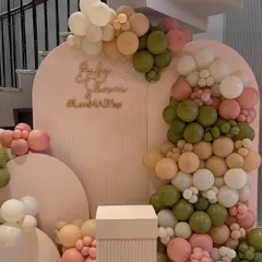 Another view of the "Mashup of Love" baby shower decor. The layered, arched backdrops with ribbed textures and a custom gold sign add depth and sophistication to the balloon arrangement.