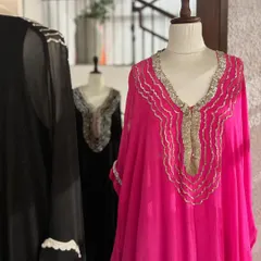 A closer look at the fuchsia kaftan, highlighting the delicate gold and silver embroidery that elevates the simple silhouette.