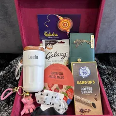 This Rakhi hamper for a sister is packed with self-care goodies. It includes a personalized tumbler and clutch, a face mask, coffee sticks, and chocolates, all presented in a luxurious velvet box.