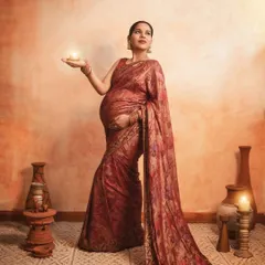 Holding a small candle or 'diya' can add a symbolic and spiritual element to your traditional maternity shoot, representing light, hope, and new life.
