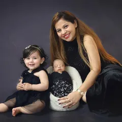 A mother with her two precious children. The big sister's happy smile as she sits next to her new baby brother is a perfect example of sibling love.