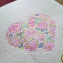 A close-up of the hand-painted watercolor puzzle heart, with delicate gold outlines on each piece. It’s these little details that make a custom card so special.