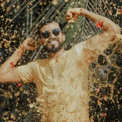 An action-packed shot of the groom getting splashed with turmeric water during his Haldi. The photo freezes the motion and captures his ecstatic expression.