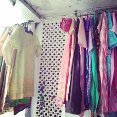 A rack of freshly stitched kurtis and suits ready for delivery. Every piece is carefully crafted to meet our client's specific requirements.