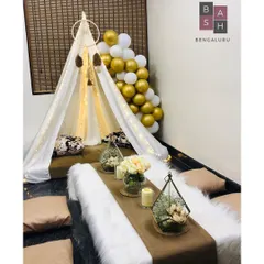 For a cozy and chic birthday, we created this beautiful boho-themed tent experience. The setup includes a fairy-lit canopy, low seating with plush cushions, a faux fur runner, and elegant floral terrariums, perfect for an intimate celebration at home.