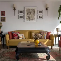 A mustard yellow sofa brings a pop of color to this calm, textural living room. The space, part of the 'Inde Blue' project, was designed to feel like a deep exhale, with a focus on handmade imperfections and soulful, personal touches.