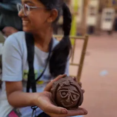 The proud smile of a young girl holding the clay face she sculpted at our community workshop. It is amazing to see what people can create when given a little guidance and a ball of clay.