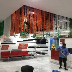 An office reception area transformed with a ceiling installation of saffron, white, and green flower garlands. This is an elegant way to bring the national colors into a corporate space for Independence Day.