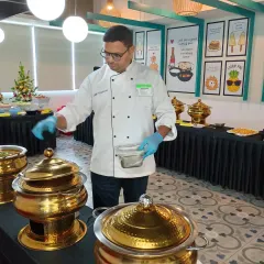 Our head chef overseeing the buffet setup at a corporate event. He ensures that every dish meets our high standards of quality and presentation before the service begins.