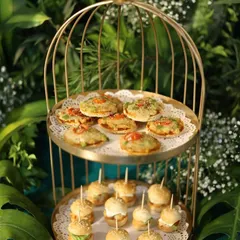 Our "mini food for the mini you" concept is a favorite. Here are our freshly made mini pizzas and burgers, served in a beautiful golden birdcage stand, perfect for a whimsical and delicious touch.