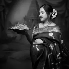A stunning black and white portrait that feels like a vintage painting. The traditional attire and props create a timeless and artistic image.