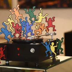 'The Beat Goes On,' a metallic installation paying homage to 80s pop art and music. A classic record player becomes a dance floor for colorful figures inspired by Keith Haring's iconic line work.