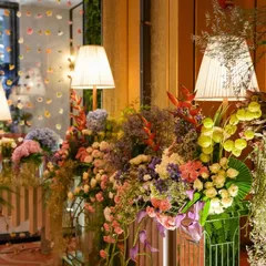 A close-up of the pastel floral arrangements, showing the beautiful mix of colors and textures. The soft lighting from the table lamps adds a touch of warmth to the daytime setup.