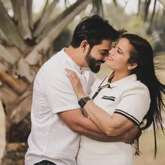 Sometimes the simplest moments are the most beautiful. This is a candid, romantic shot from a pre-wedding session in a park. The natural light and greenery provide a soft backdrop, allowing the couple's close embrace and gentle expressions to be the main focus.