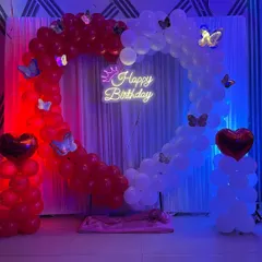 The red and blue lighting gives this birthday balloon setup a vibrant, party-ready look.