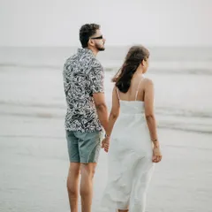 A thoughtful pose of the couple looking out at the ocean. This kind of shot adds a cinematic and contemplative mood to your pre-wedding album.
