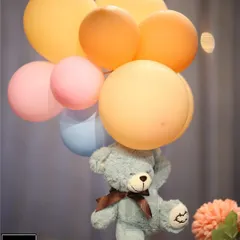 A close-up of a floating teddy bear centerpiece. This simple yet creative detail adds height and fun to the table decor for a "We Can Bearly Wait" themed baby shower.