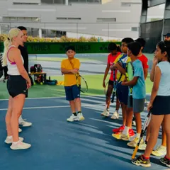 A group of young players gathered on court for a motivational talk. Exposure to professional athletes helps our students set realistic goals and cultivate mental strength.