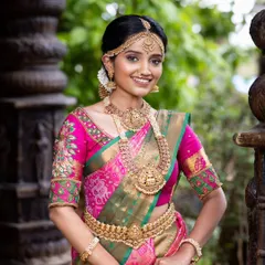 A classic South Indian bride in a stunning pink and green Kanjivaram silk saree. This timeless combination is perfect for Muhurtham ceremonies, offering traditional elegance and grace. The pure silk drapes beautifully for photos and makes you feel rooted in tradition.
