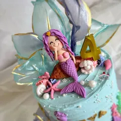 A close-up of the adorable, winking mermaid topper.