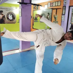 A powerful side kick in action. This karate student demonstrates excellent form and extension while training on the heavy bag, a key part of developing striking power.