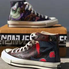 A dark and detailed Naruto theme on a pair of classic Converse high-tops. One shoe features the villain Orochimaru in a cosmic setting, while the other shows a menacing Itachi Uchiha from the Akatsuki clan.