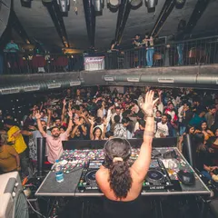 A view from my console of a multi-level club completely packed and moving to the beat. I ensure every corner of the venue feels the energy.