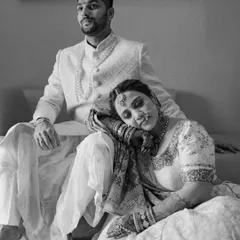 A bride rests her head on her groom's lap, a moment of quiet comfort and trust. This black and white image speaks volumes about their deep connection and the peace they find in each other.