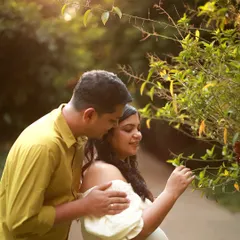 A quiet moment during an outdoor maternity shoot. The golden sunlight filters through the trees as they share a peaceful moment, nurturing their love and new beginnings.