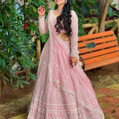 A full-length shot showing the bride's stunning pink lehenga. The simple diamond set is the perfect choice, adding elegance without distracting from the outfit's heavy embroidery.